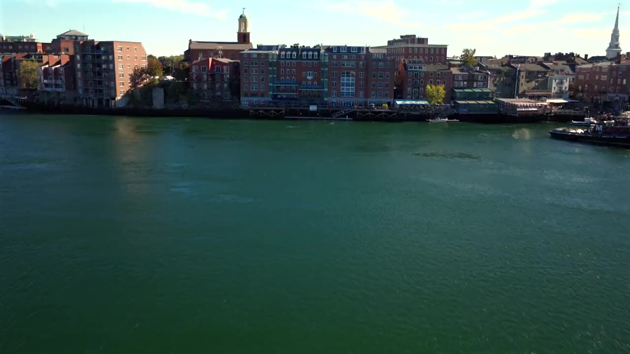 The Portsmouth waterfront seen from the river, brick buildings and a church spire along the quay