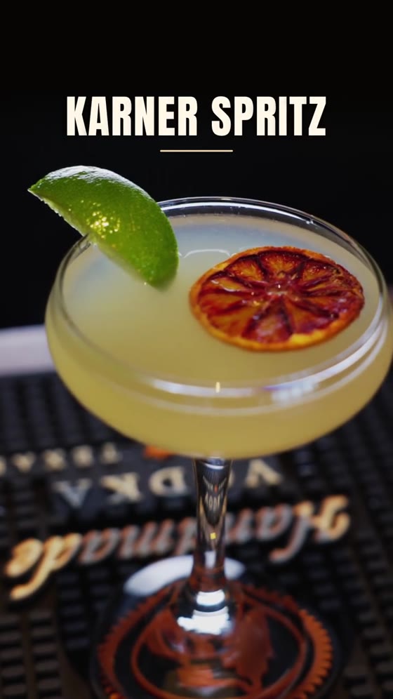 A coupe glass of pale citrus cocktail garnished with lime and a blood orange wheel, under a title card reading Karner Spritz